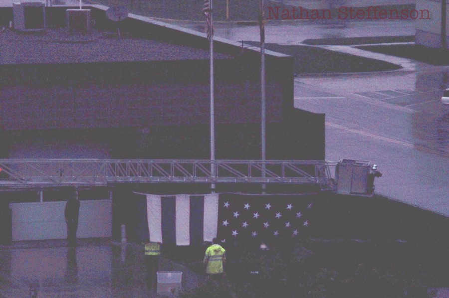 firefighters putting flag on ladder truck firefighters putting flag on ladder truck