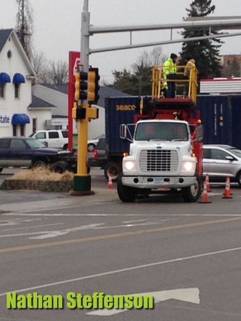 workers putting up sign in wintry mix