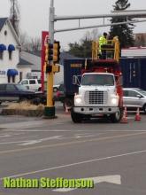 workers putting up sign in wintry mix