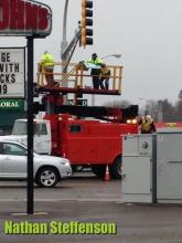 workers putting up sign in wintry mix